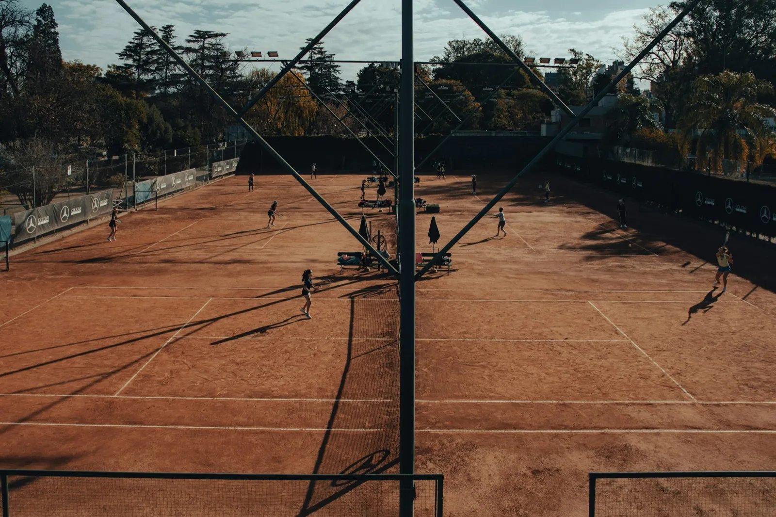 Aerial view of clay tennis courts with players competing