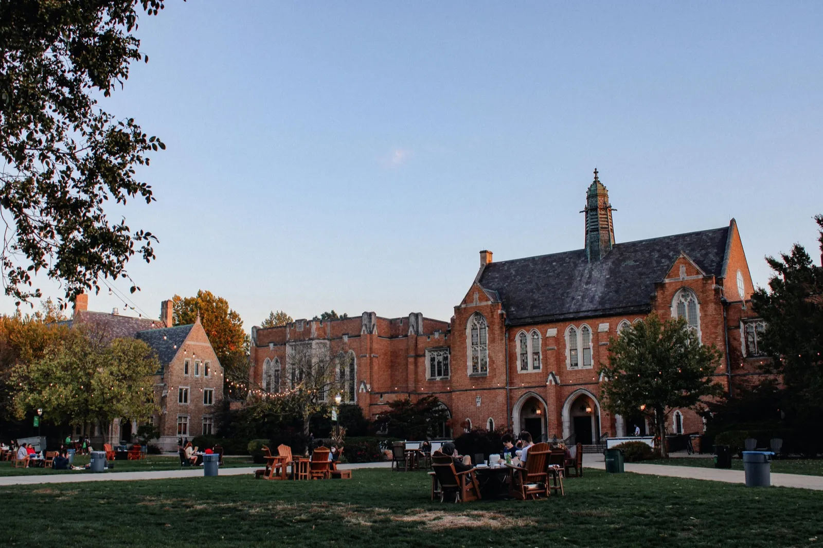 Gothic brick campus buildings with green lawns at dusk
