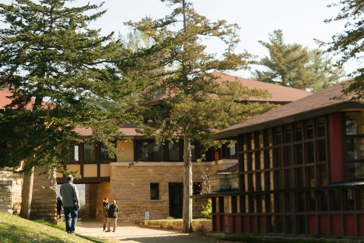 A parent and student walking toward a college campus building during a campus visit
