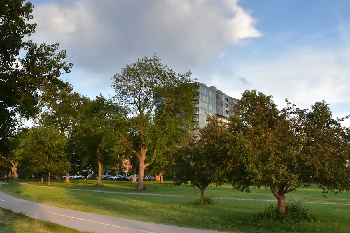 Stadium lights illuminating a football field at dusk with stands visible in the background