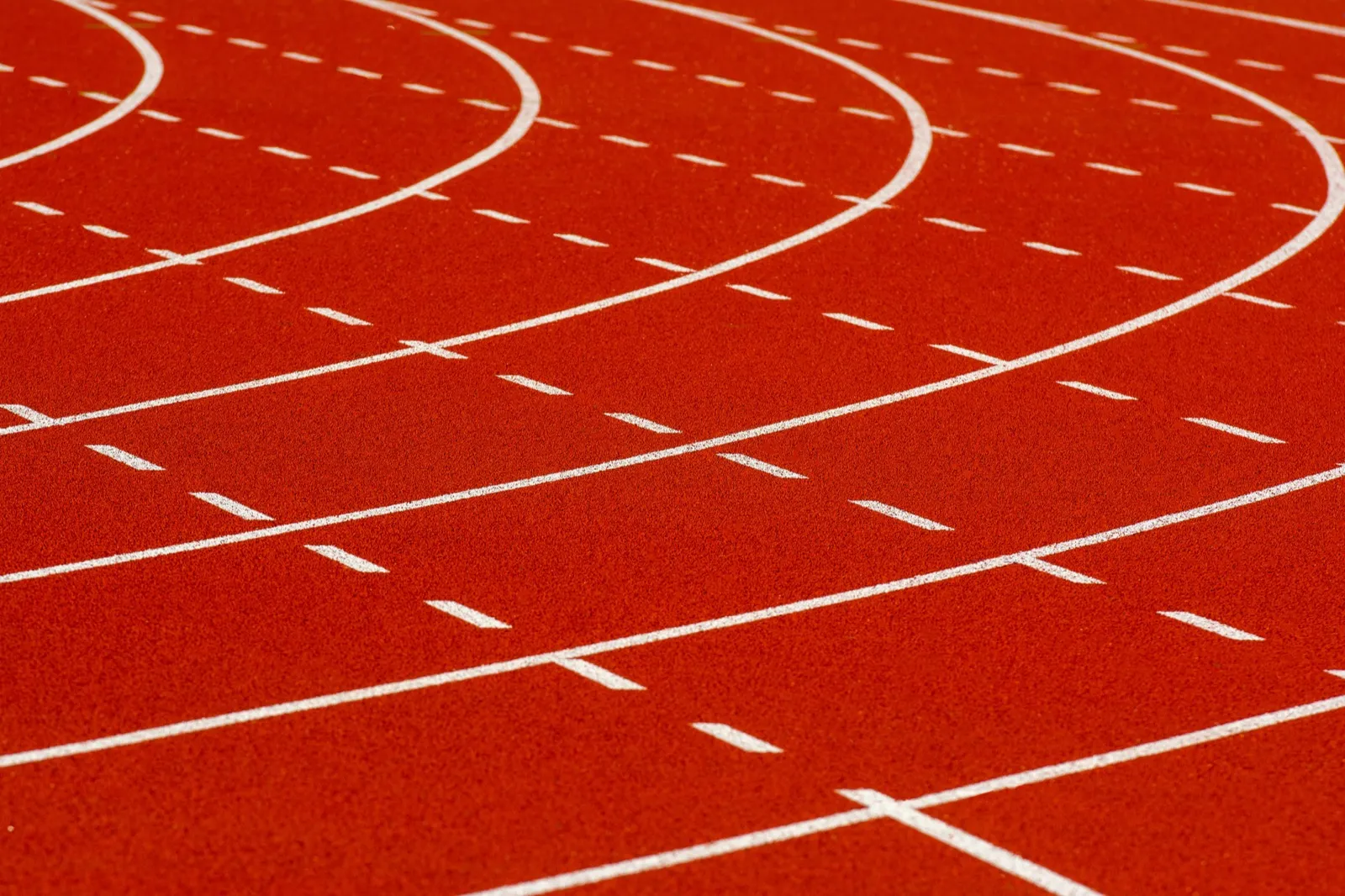 Close view of red running track lanes at a college athletics facility